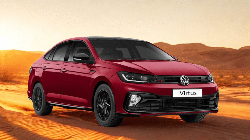 Red Volkswagen Virtus GT sedan in desert landscape at sunset, showcasing sporty black alloy wheels, bold front grille, and dynamic GT styling