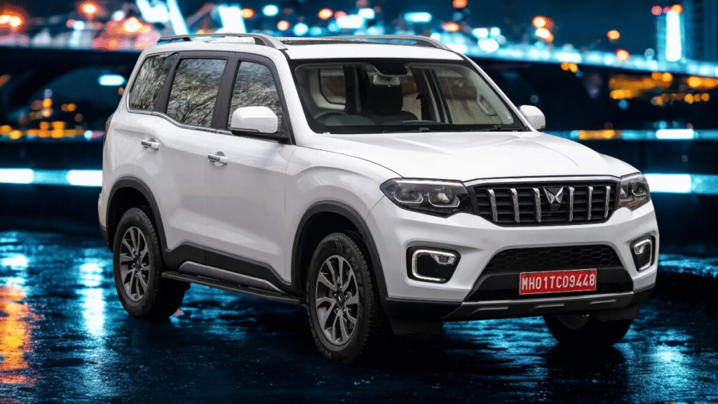 Mahindra Scorpio N parked under a flyover at night in an urban cityscape, glowing with neon reflections to showcase its bold road presence in city environments.