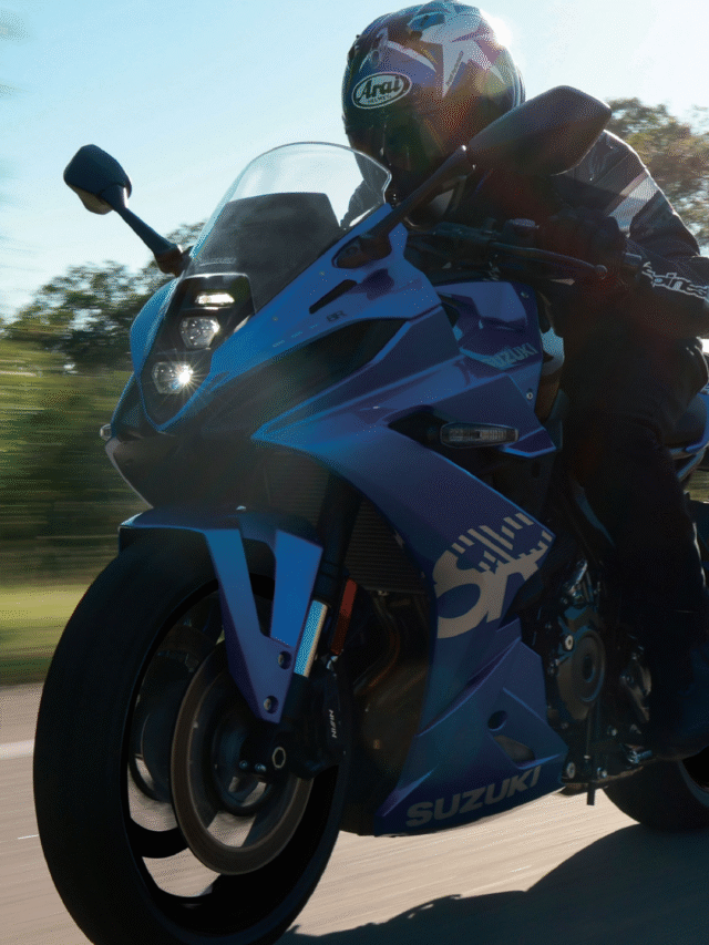 Rider on a Suzuki GSX-8R sportbike cruising through a modern city street during daytime, showcasing urban riding versatility.