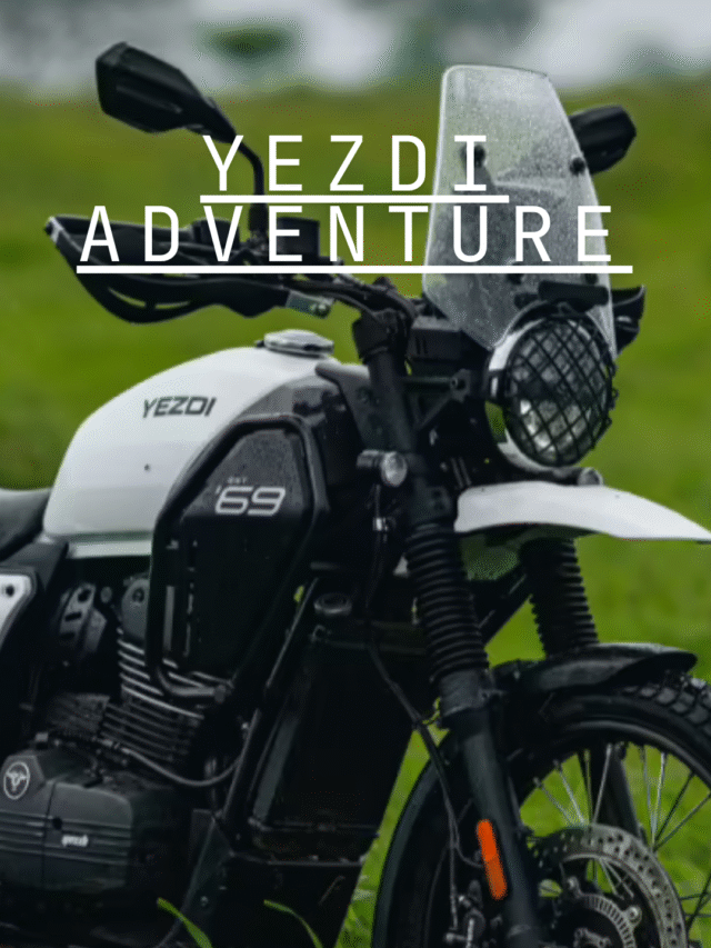 A Yezdi Adventure motorcycle parked on a winding mountain road with panoramic Indian landscapes in the background.